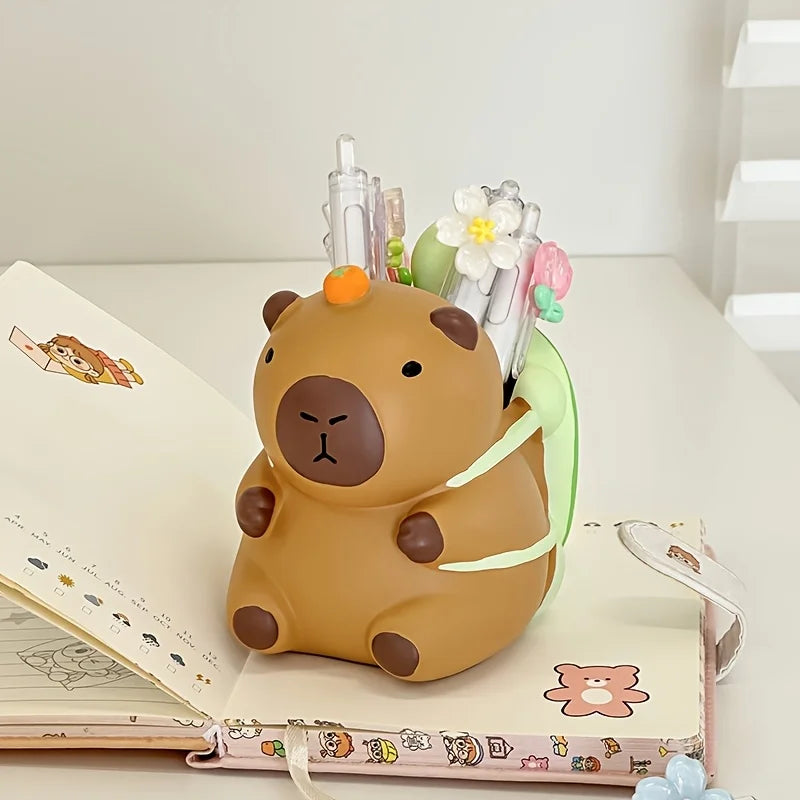 Capybara turtle backpack pen holder organizing pens on a desk with a notebook