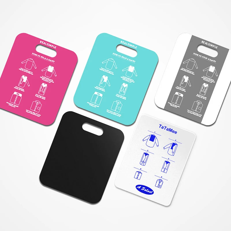 Assorted folding boards in magenta, mint green, white, black, and gray, shown flat with printed shirt folding instructions