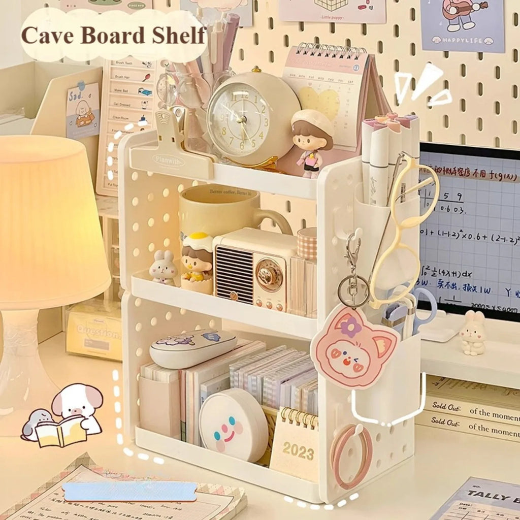White multi-tier pegboard desktop organizer styled on a cozy home office desk with pens, books, and small decor