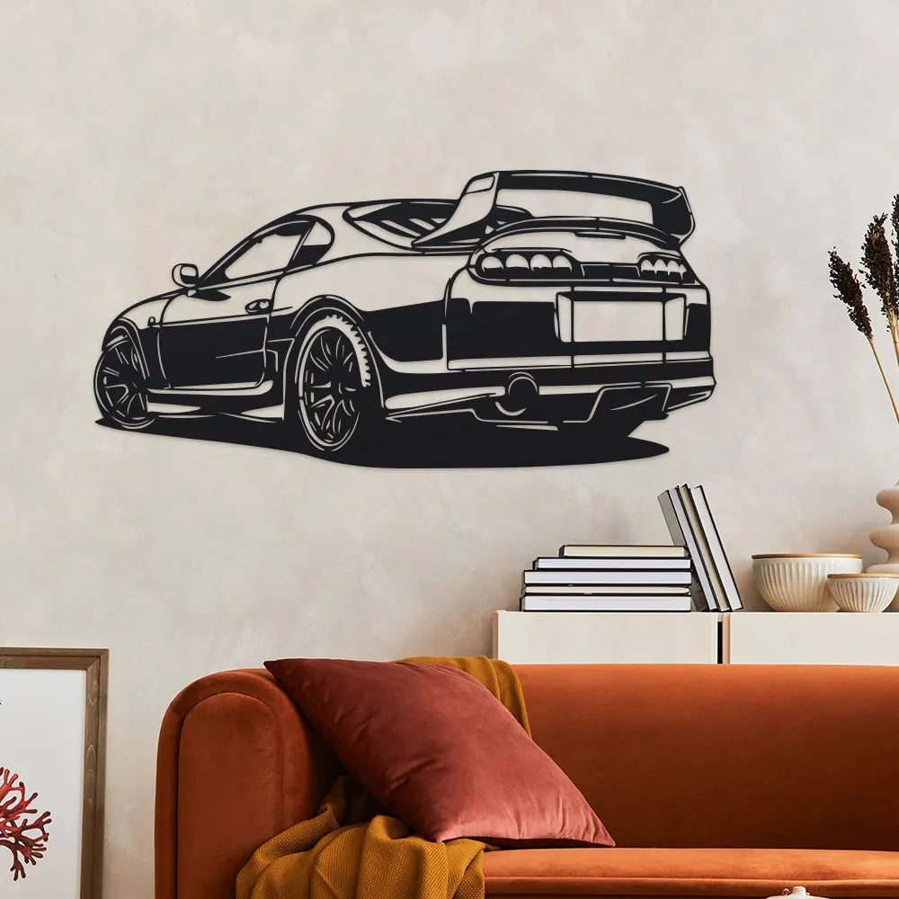 Black metal car silhouette wall art mounted above a rust-colored sofa