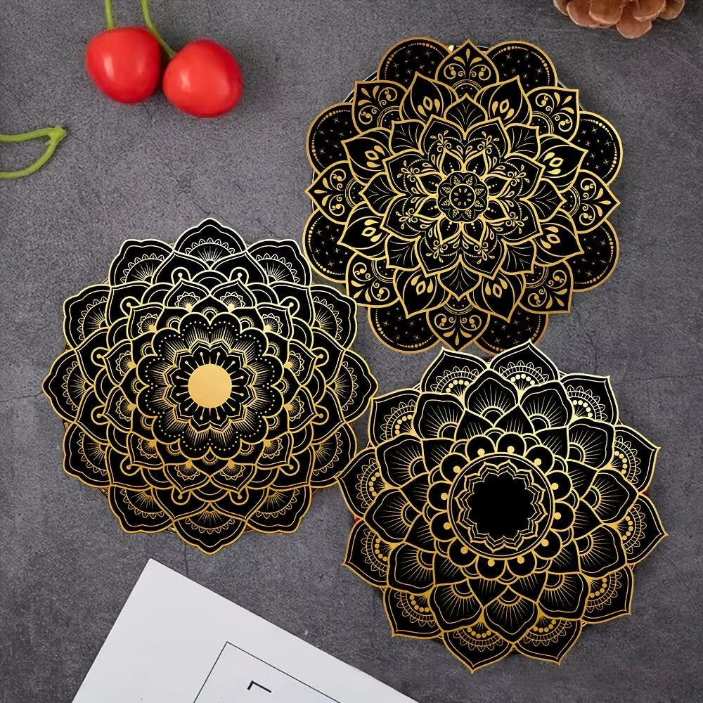 Three black and gold round mandala pattern coasters displayed on a gray surface