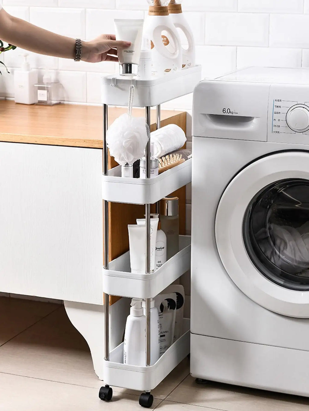 white slim rolling utility cart with three shelves holding bath and laundry products beside a washing machine