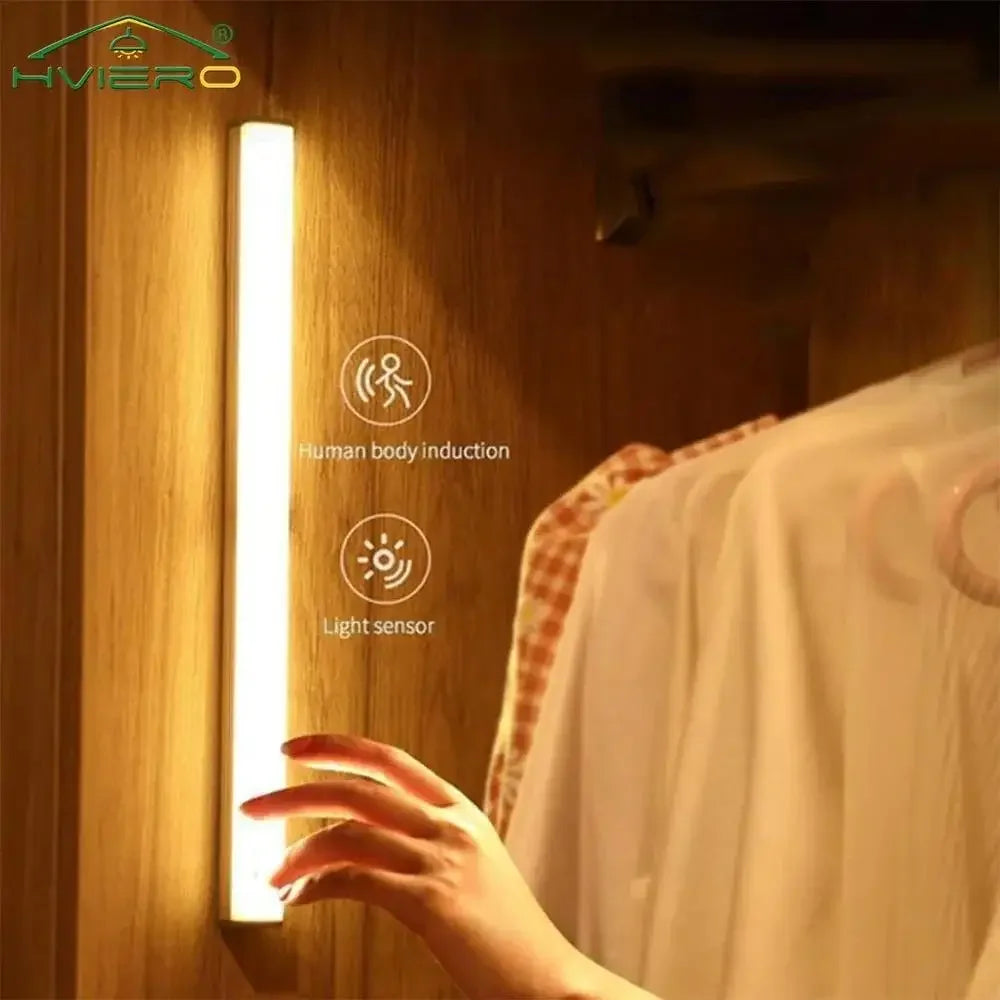 Motion sensor LED light mounted in wardrobe with clothes, hand activating