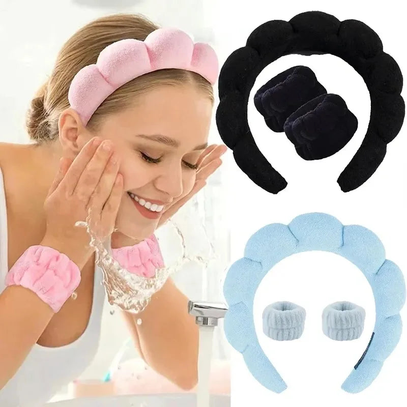 woman washing face at bathroom sink wearing pink padded spa headband and matching wristbands; black and blue versions pictured alongside