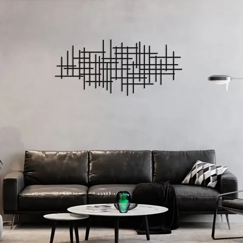 Black geometric grid metal wall art sculpture mounted above a modern black sofa in a living room