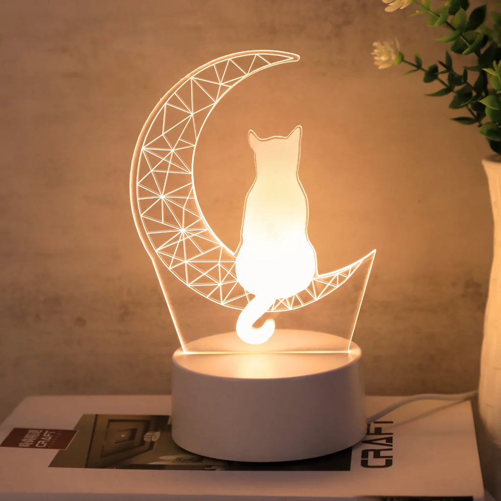 Moon cat decorative desk lamp with warm yellow light near a potted plant