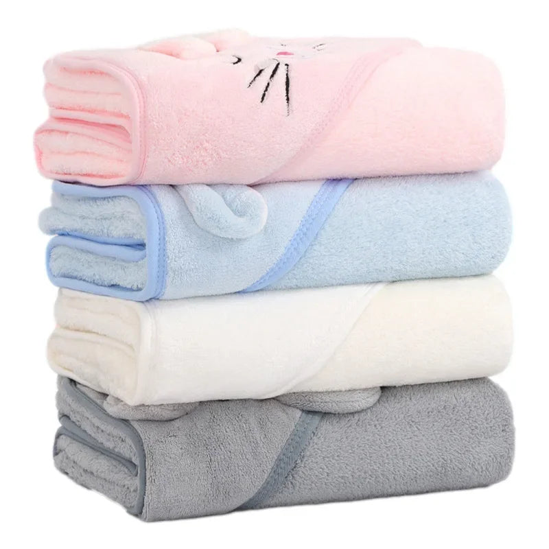 Stack of folded animal hooded baby towels in pink, blue, white, and gray coral fleece
