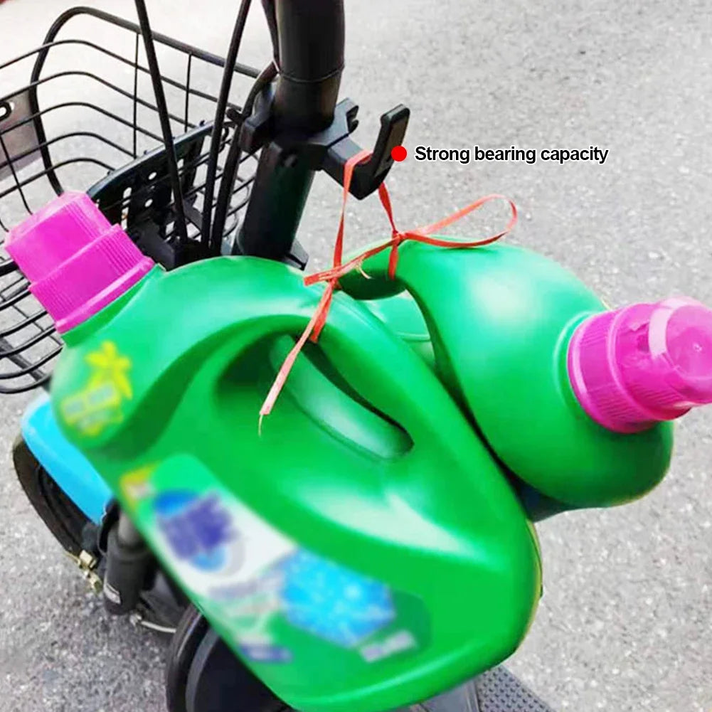 Handlebar hook holding two shopping jugs on an e-bike.