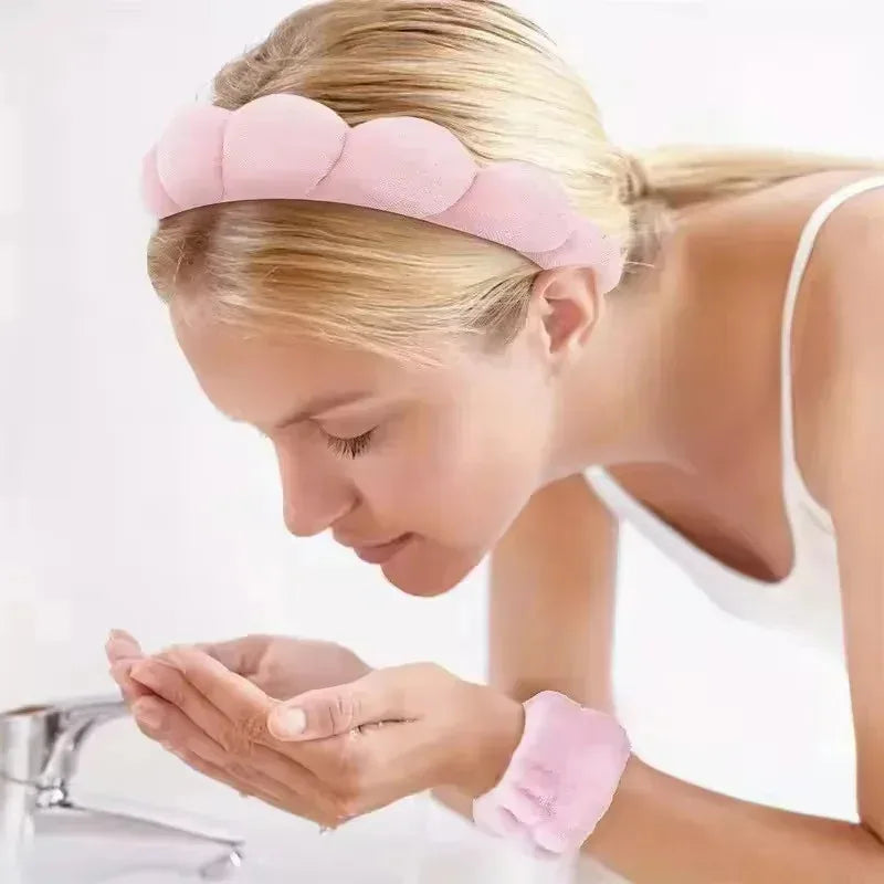 Woman washing face at the sink with pink spa headband and wrist strap set