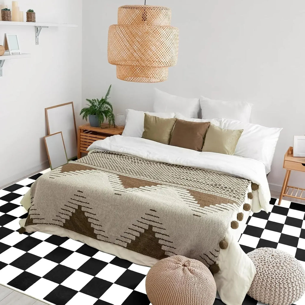 Black and white checkered area rug in a cozy bedroom under bed with neutral bedding and poufs