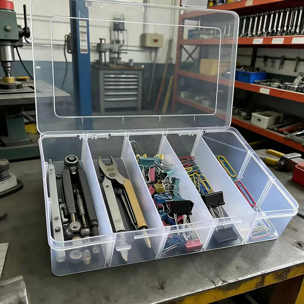 Clear plastic organizer box with 5 compartments storing tools and office clips on a workbench
