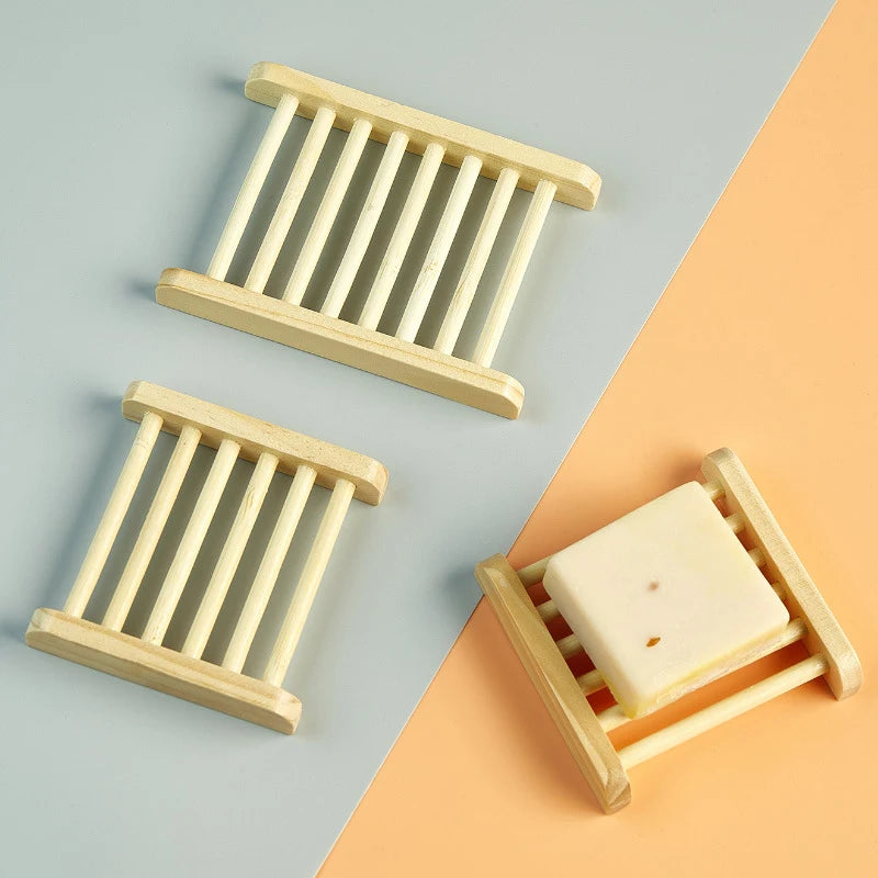 Three light wood slatted soap dishes, one holding a bar of soap
