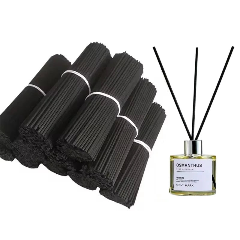 Bundles of black fiber reed diffuser sticks next to a diffuser bottle shown in home setting