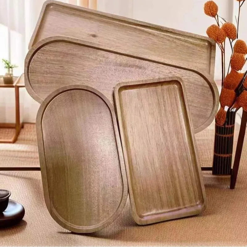 Oval and rectangular wooden trays displayed upright on a tabletop in a sunlit room