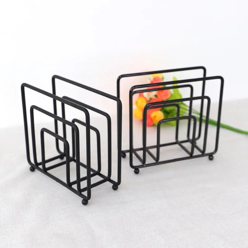 Pair of black square metal napkin holders on a light table