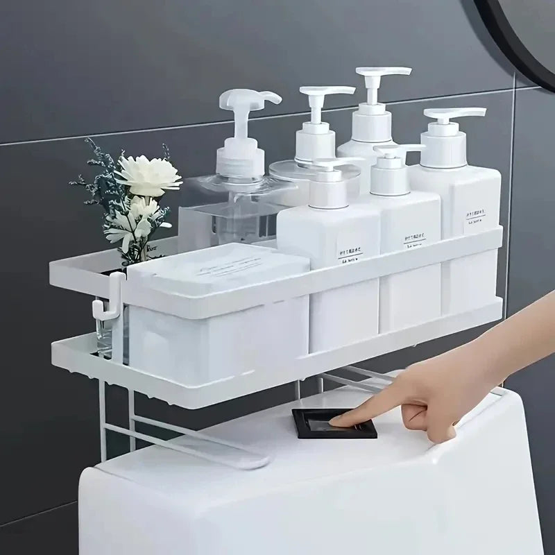 white metal over-the-toilet storage shelf holding bottles and toiletries above a toilet