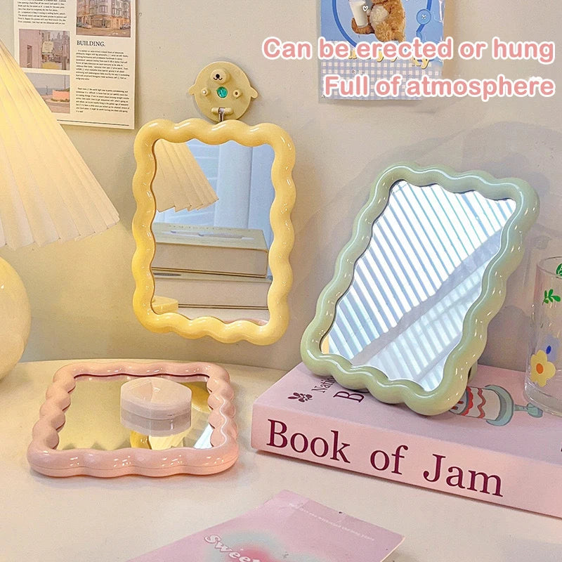 Pastel yellow, green, and pink wave edge mirrors shown on a desk and wall for versatile styling.