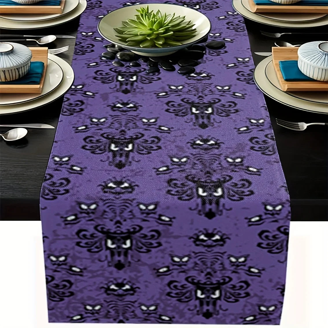 Purple linen Halloween table runner with haunted ghost pattern on dark dining table setting