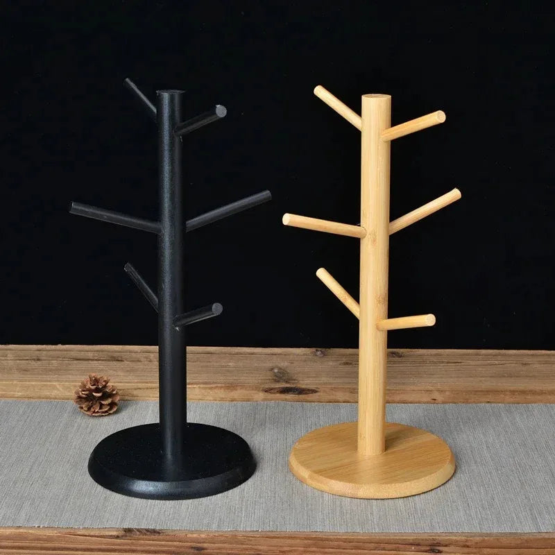 Black and beige wooden mug holder stands side by side, each with six angled hooks, against dark background.