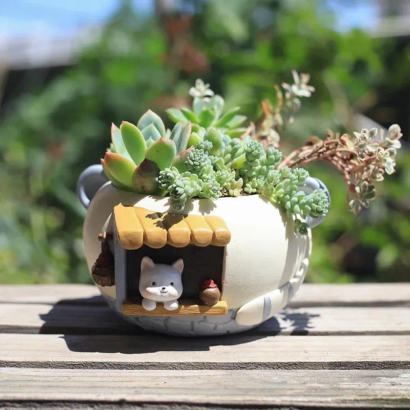 Mini resin planter pot with kitten house scene, planted with succulents, outdoors