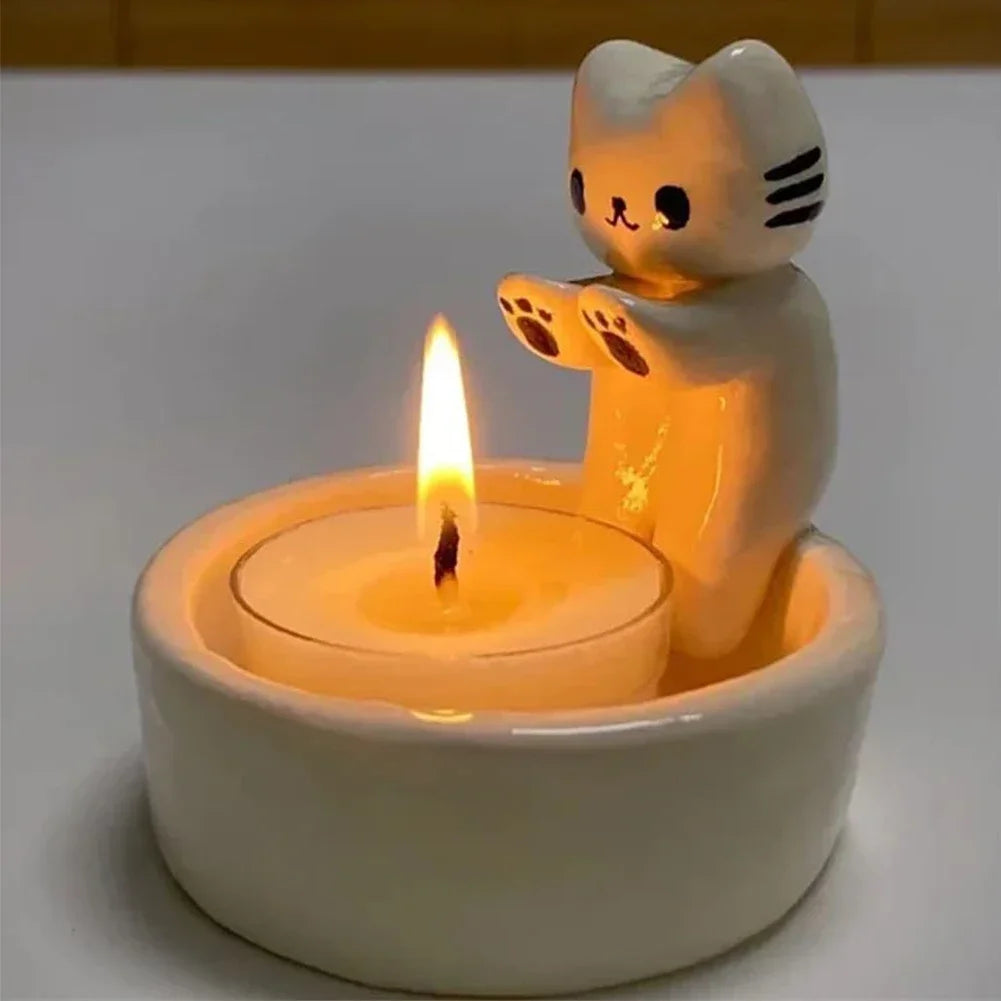 cat tealight candle holder with resin kitten and lit candle on a table