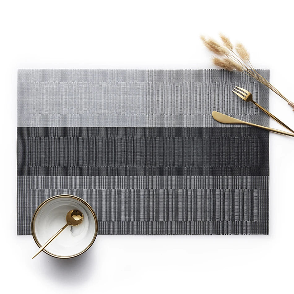 Gray and black striped PVC placemat styled with gold cutlery and bowl