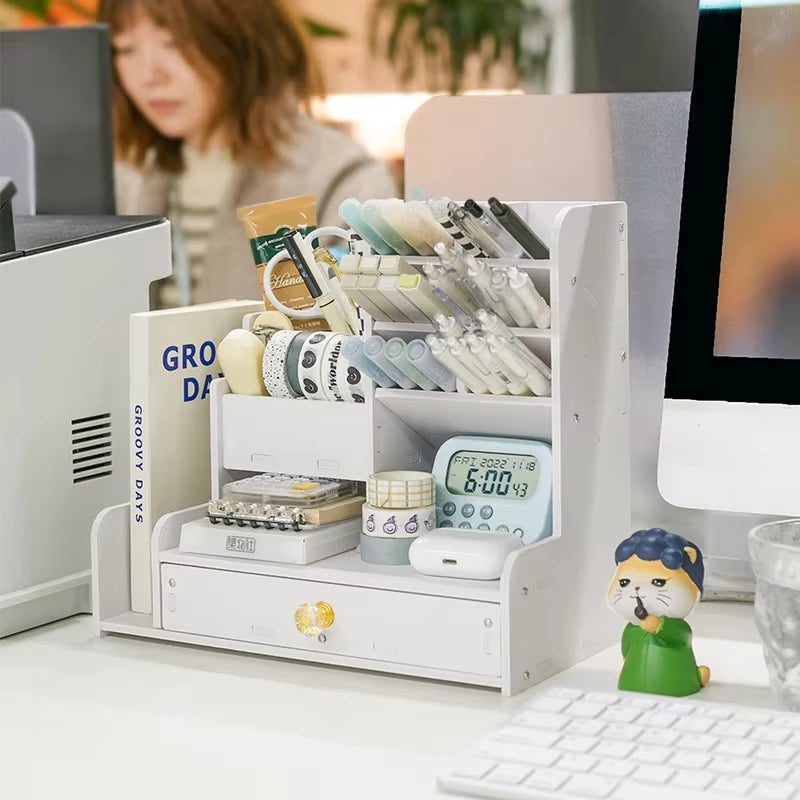 white desk organizer with compartments and drawer holding office and craft supplies in a work environment