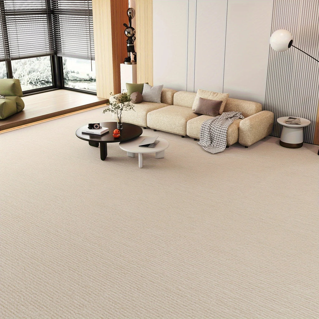 Beige solid color runner rug installed wall-to-wall in a bright living space