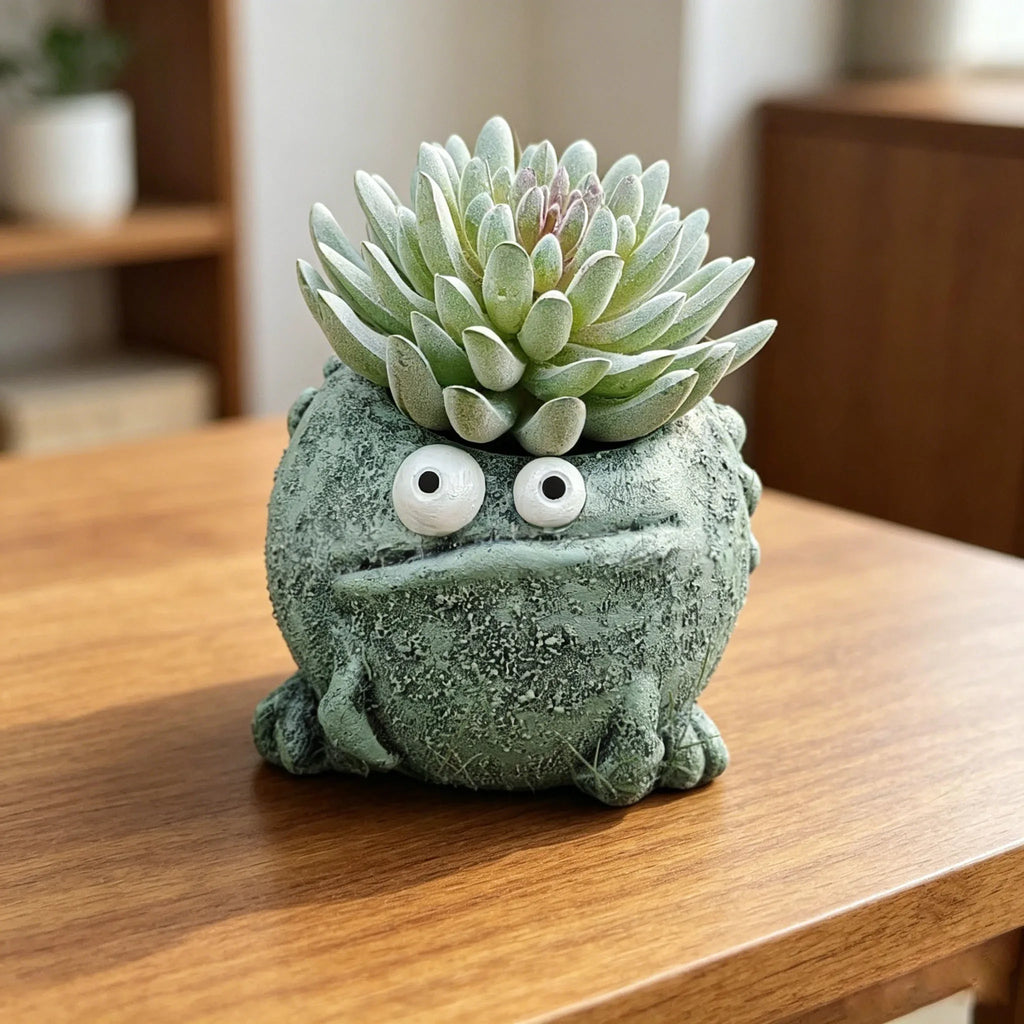 Textured resin frog-shaped planter with succulent, on a wooden desk