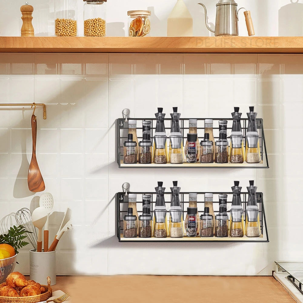 Black metal and wood wall-mounted shelves holding spices, oils, and seasonings on a white tile kitchen wall