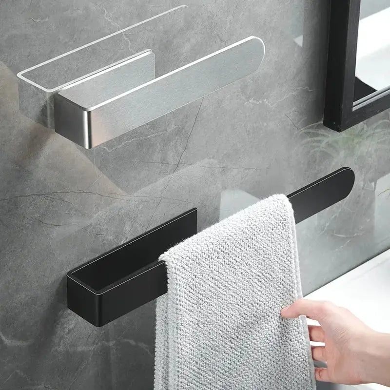 Self-adhesive stainless steel towel rack shown in black and brushed steel with a towel hanging in a bathroom