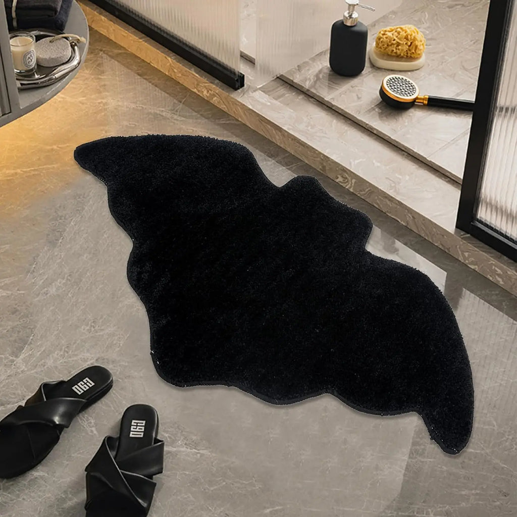 Black bat shaped bathroom rug on a tile floor near a shower in a modern bathroom