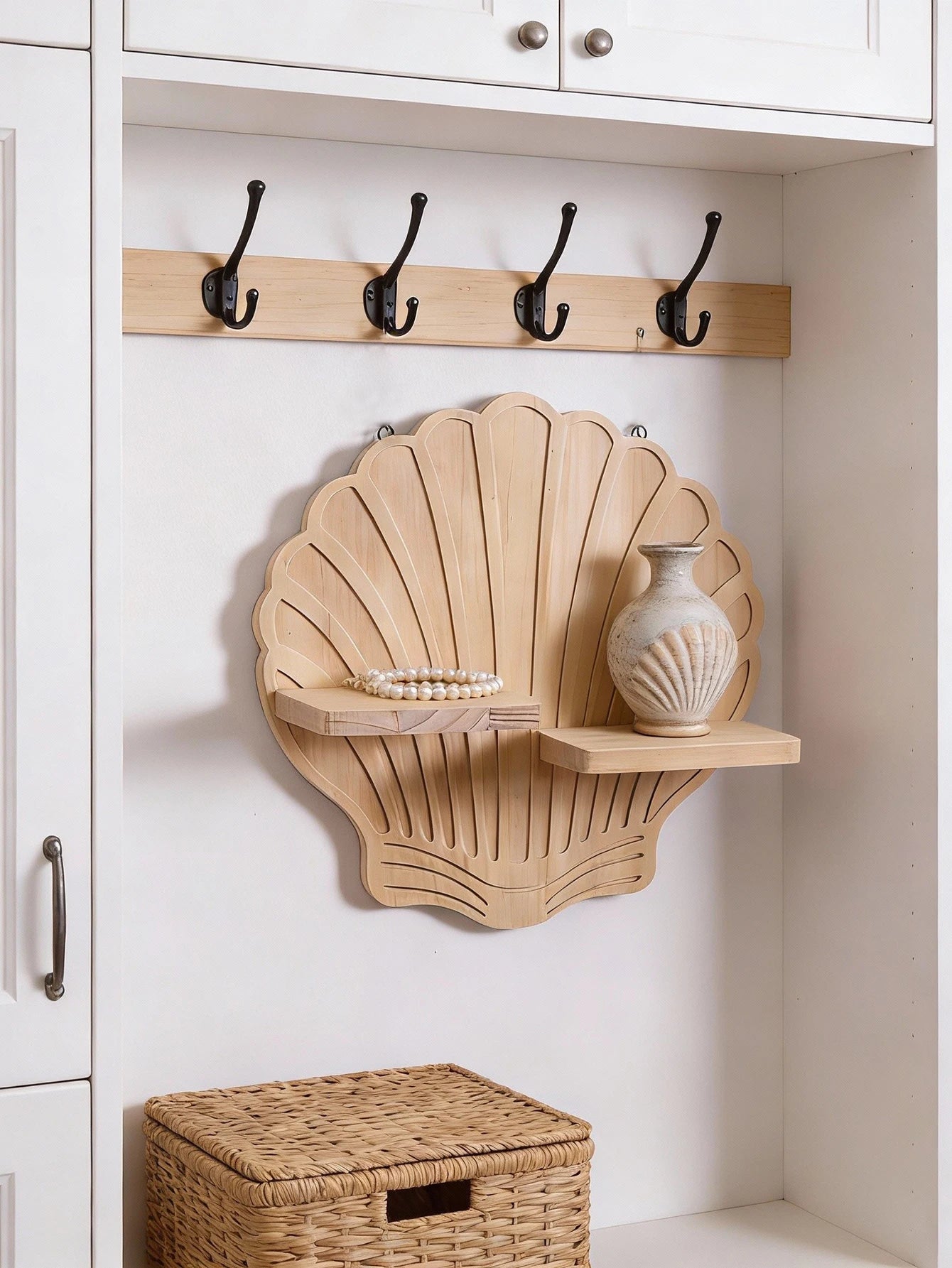 Seashell design wooden wall shelf mounted in an entryway cubby with hooks and neutral woven basket—shown organizing vase and jewelry.