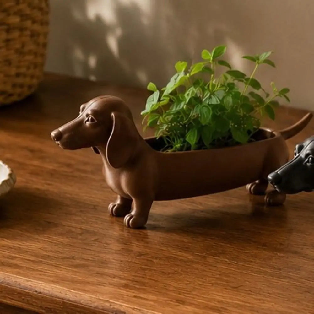 Brown dachshund tray used as a small planter with greenery on a dresser