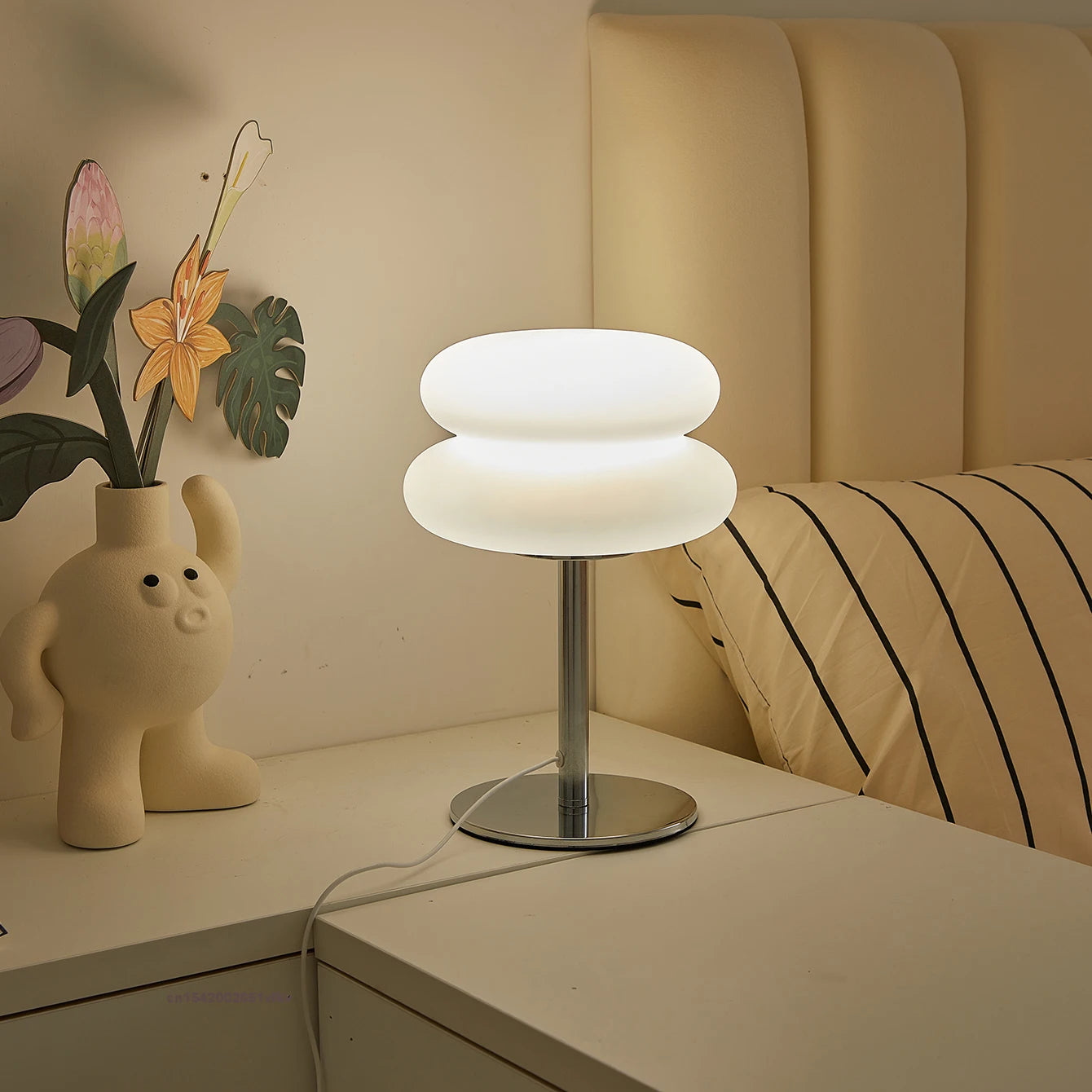 Cloud-inspired table lamp with white light on a nightstand in a cozy bedroom setting