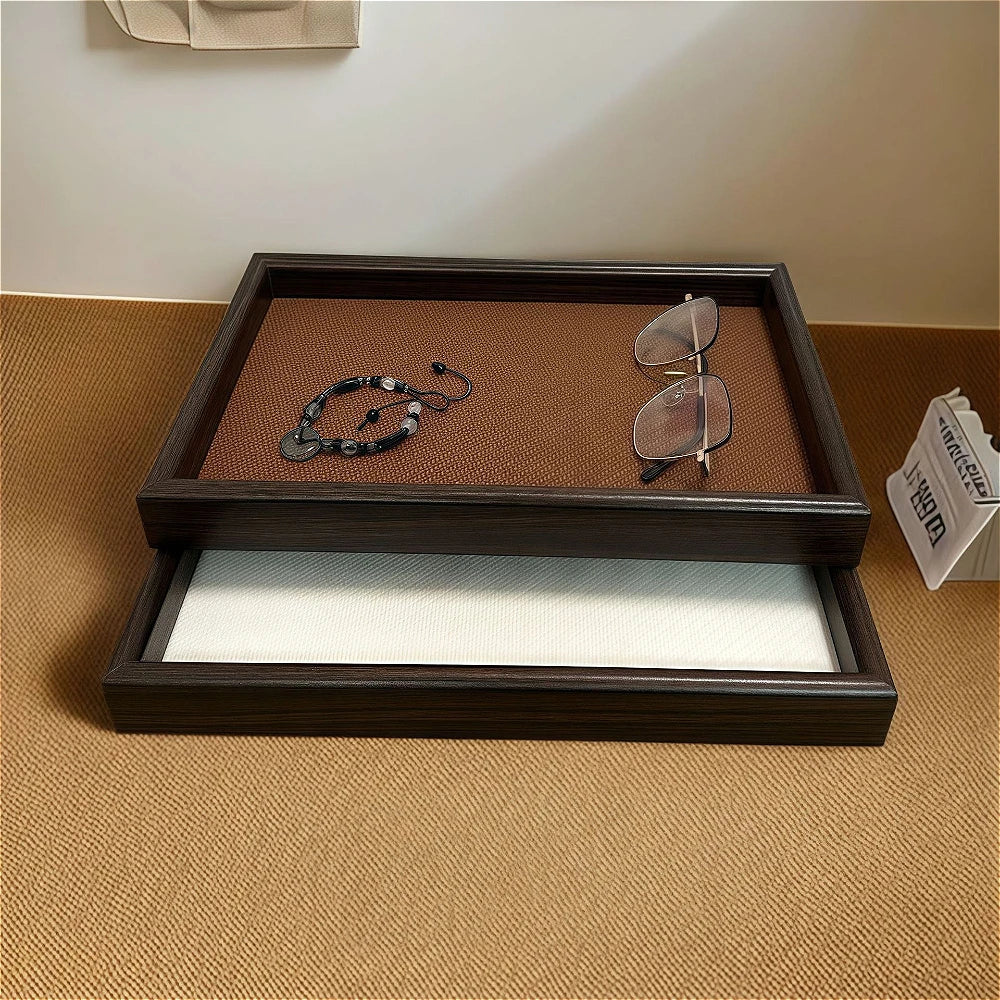 Brown and white rectangular faux leather storage trays with bracelet and glasses on a surface