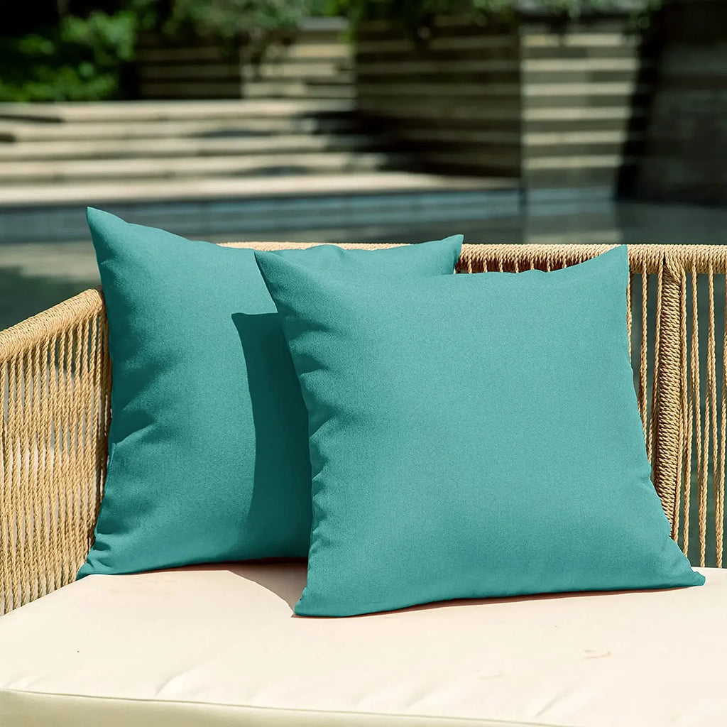 Teal waterproof outdoor cushion covers on a patio loveseat