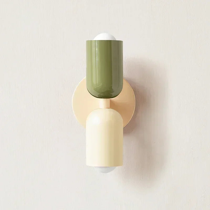 Close-up of green and cream macaron metal wall lamp on beige wall