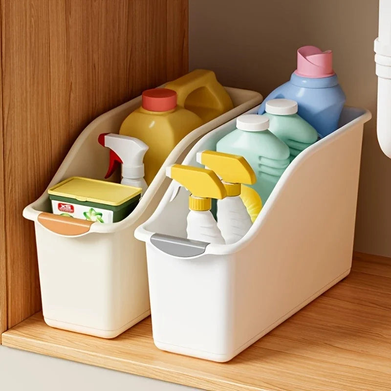 Two curved plastic storage bins under a cabinet shelf holding cleaning supplies