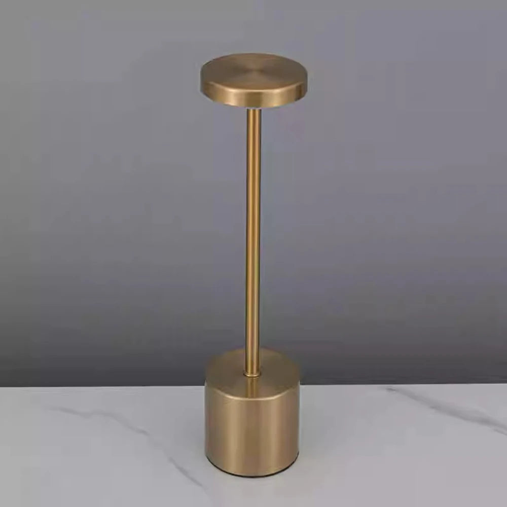 Modern gold rechargeable table lamp in a minimalist room