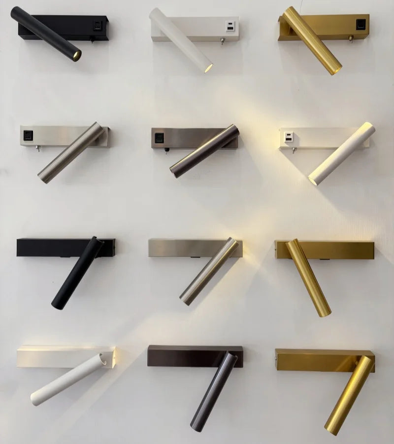 Selection of rotating wall lights in black, white, gold, and silver finishes on display