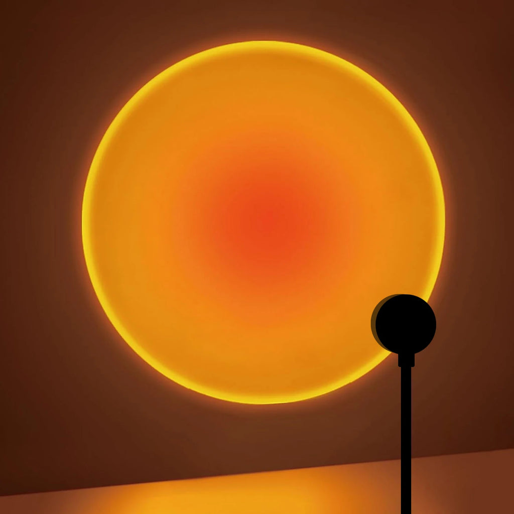sunset projection lamp casting a large warm orange circle of light on a wall