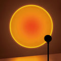 sunset projection lamp casting a large warm orange circle of light on a wall
