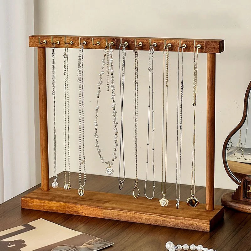 Freestanding wooden jewelry stand with necklaces on vanity table