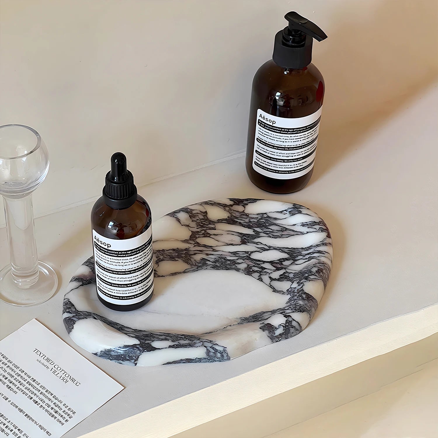 Marble effect ceramic tray on counter holding bottles