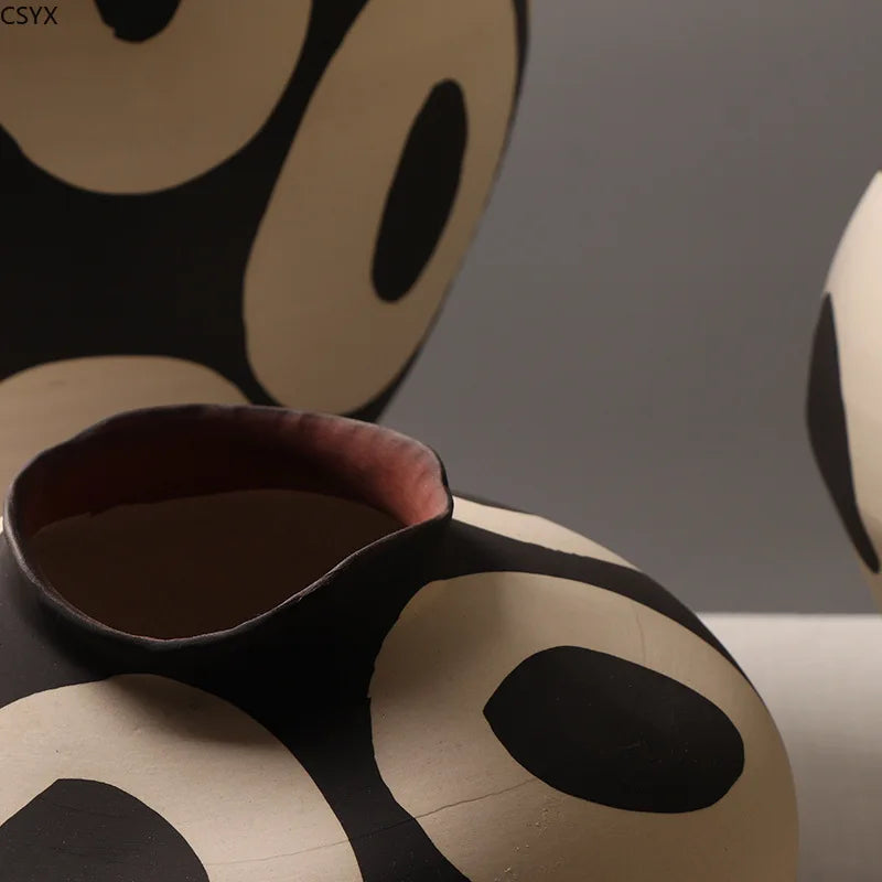 close-up showing the mouth and hand-drawn pattern of the geometric ceramic vase