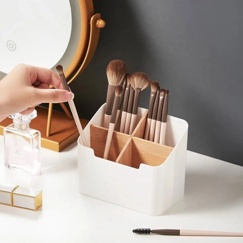 white organizer box with four compartments holding makeup brushes on a vanity
