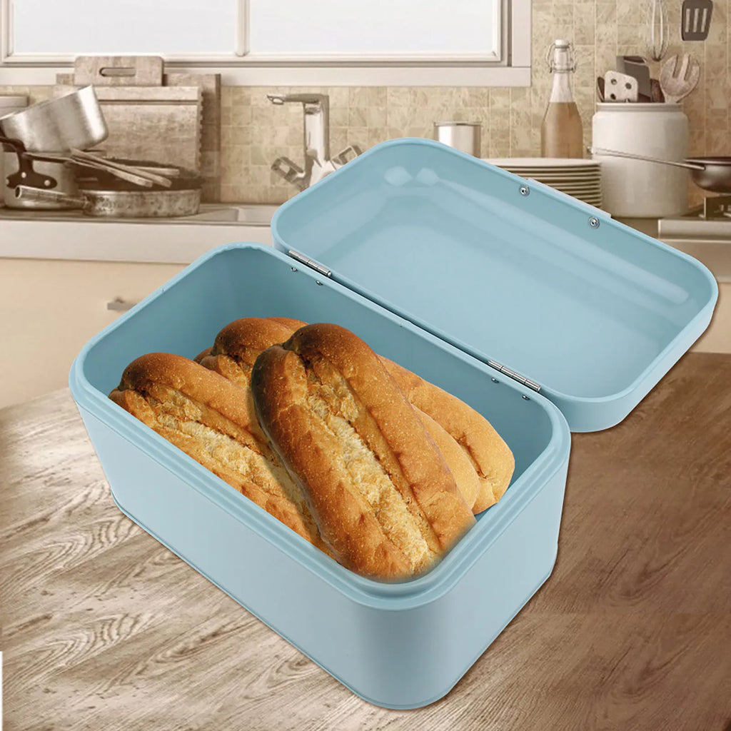 Light blue metal bread box open on a kitchen table with bread loaves inside