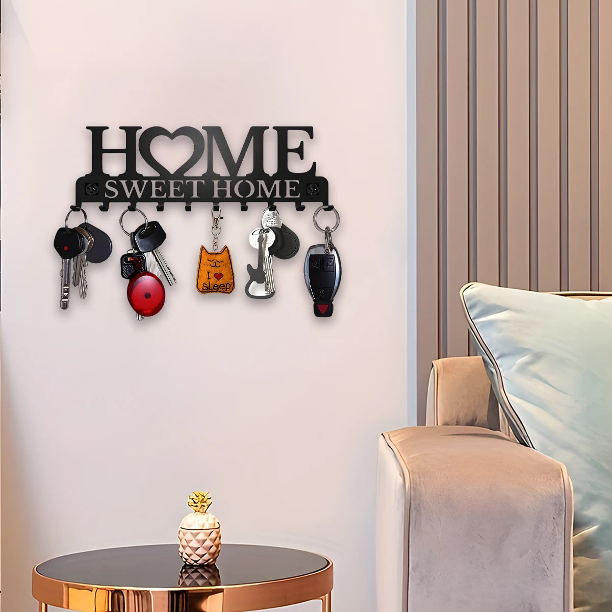 Key holder installed on a wall next to a side table and armchair, holding keys and accessories.