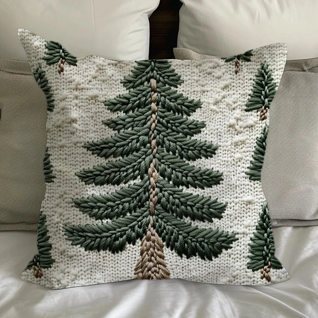 Decorative pillow cover with green evergreen tree print on white fabric, styled on a bed